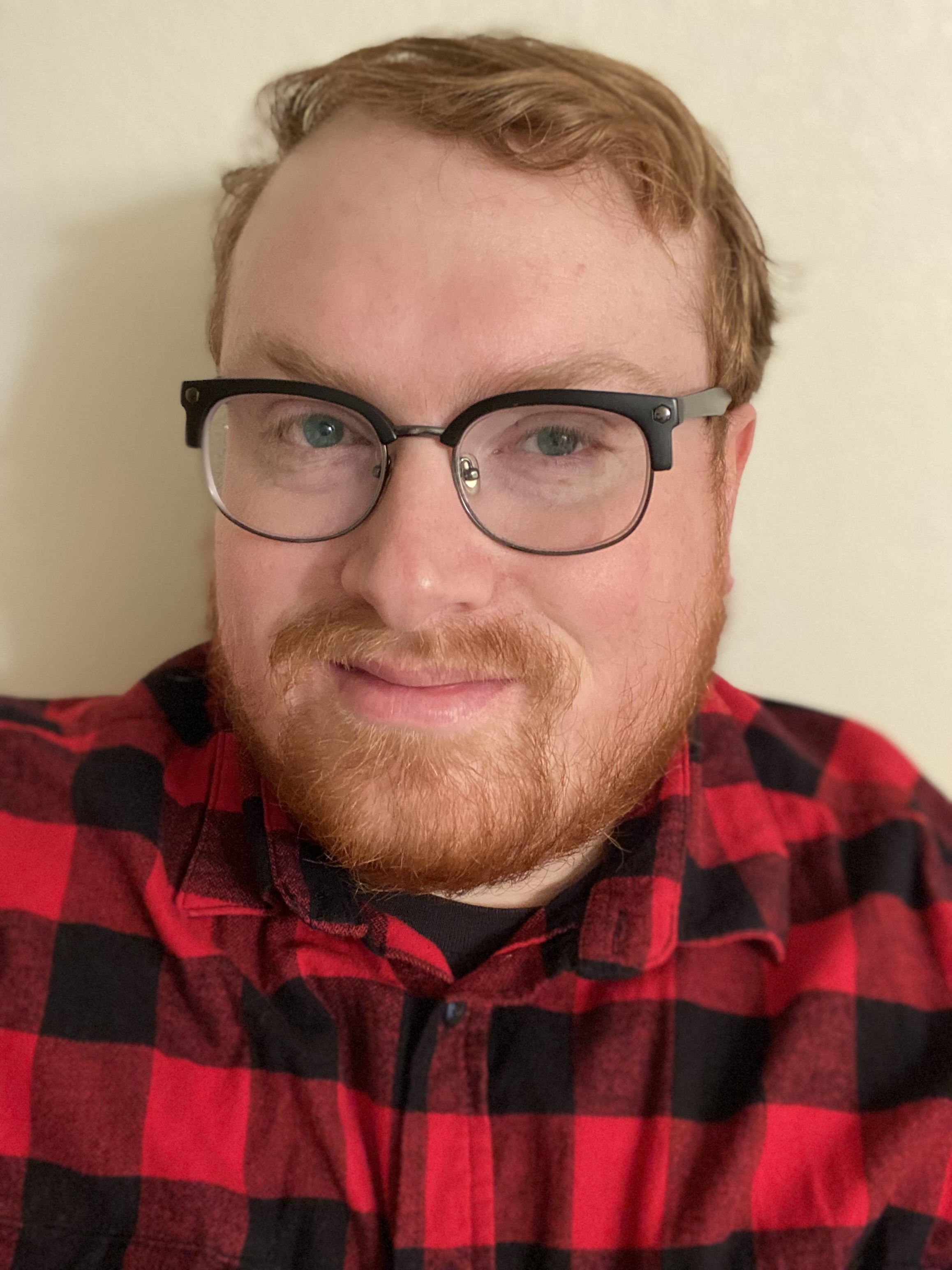 A headshot of Alexander Miller. He is wearing his glasses, has short cut hair and a nicely trimmed beard.